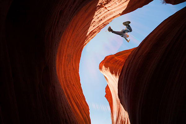 A person jumping a gap in a canyon