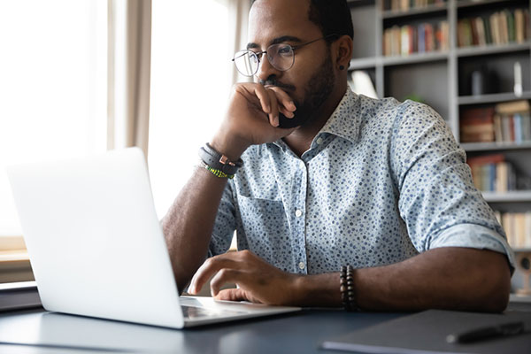 An investor sat at a laptop studying fund, trust and ETF data