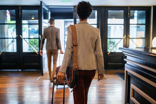 A woman pulls a suitcase in a hotel lobby