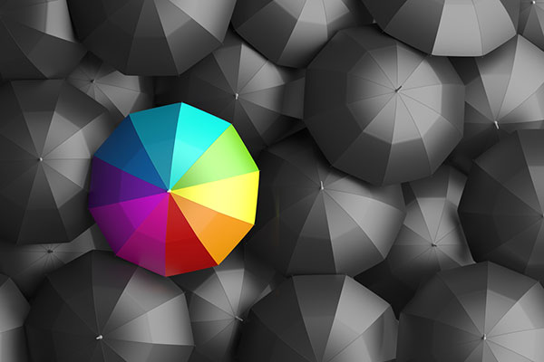 Rainbow umbrella amid grey umbrellas