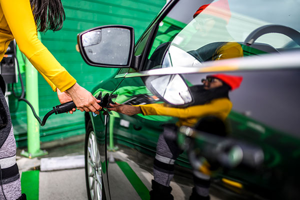 A woman charging an electric vehicle