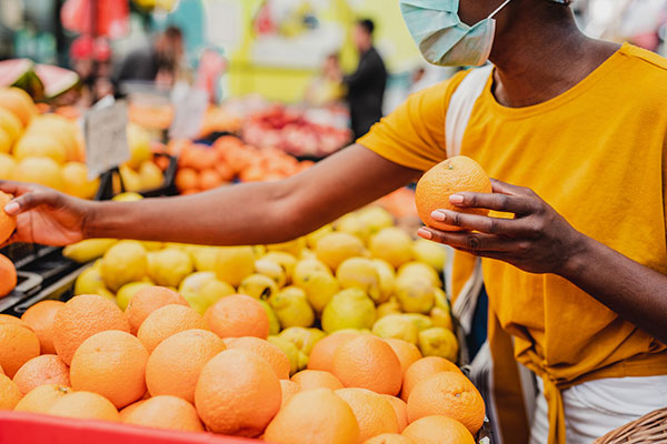 A woman choosing citrus fruit at a supermarket