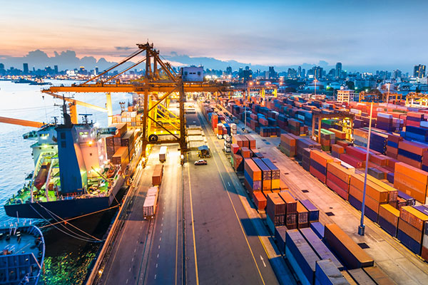 A container ship in a port in Asia at sunset