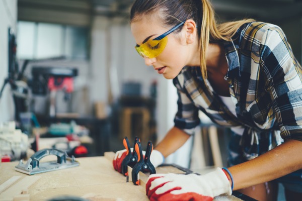 carpenter-woman-at-work-using-electric-saw