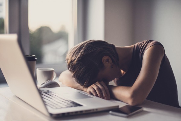 tired-businesswoman-in-the-office-with-laptop-and-coffee