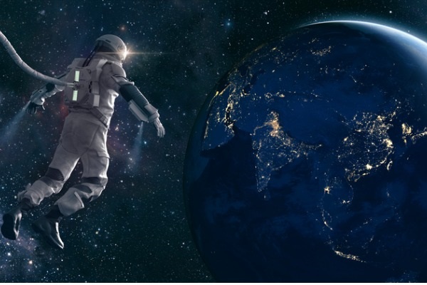 Astronaut on space walk looks at lights of planet earth picture.