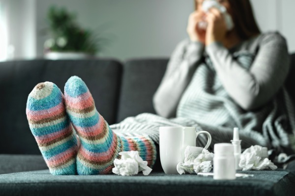 sick-woman-with-flu-cold-fever-and-cough-sitting-on-couch-at-home-ill