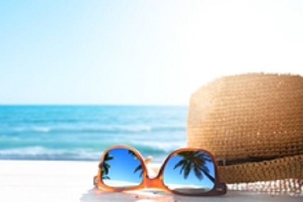 Sunglasses and sunhat on a summer beach