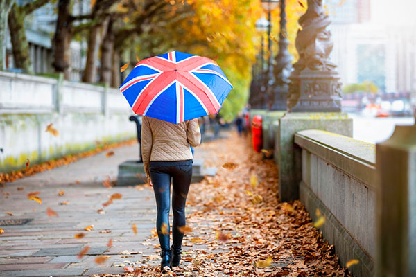 Woman walking in London with Union flag umbrella 600