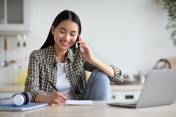 smiling asian woman phone laptop happy 600