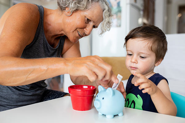 Grandmother with grandson teaching a money lesson 600