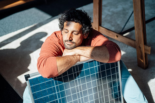 Man basking in the sun with solar panel 600