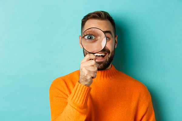 Man holding a magnifying glass 600