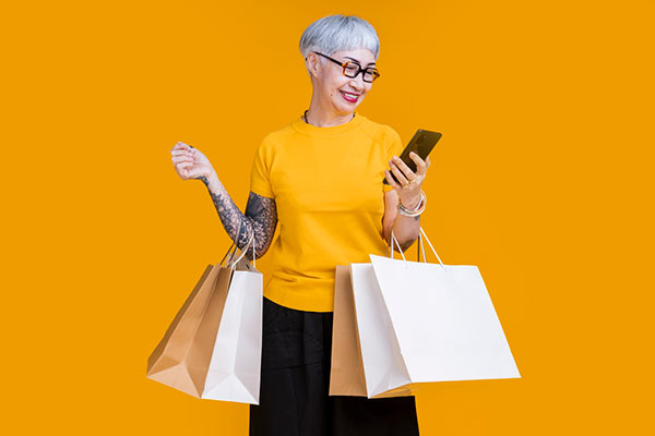 A shopper with multiple bags on her arm 600