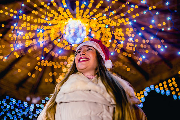 Christmas lights and woman in Santa hat 600