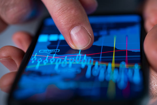 Investor studying chart on smartphone 600