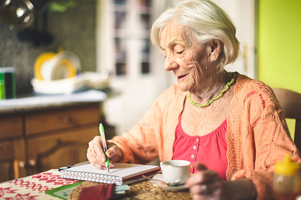 Pensioner calculating income in kitchen 600