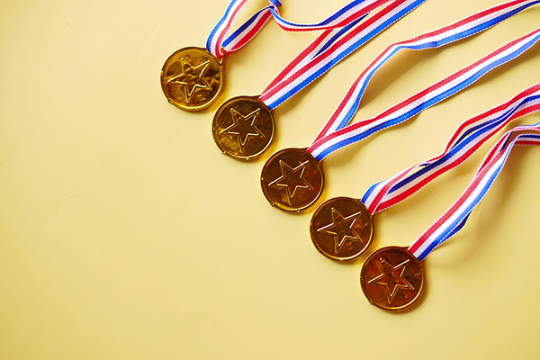 Five gold medals with stars on them 600