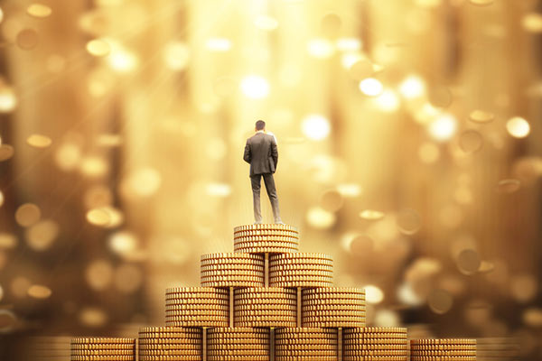 ISA millionaire: a man standing on a pile of gold coins 