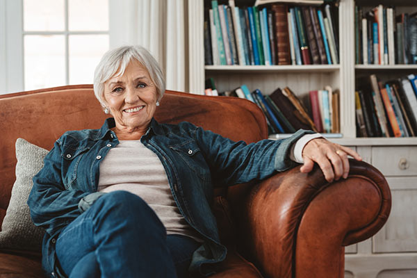 A woman approaching age 75 sitting on an armchair at home 600