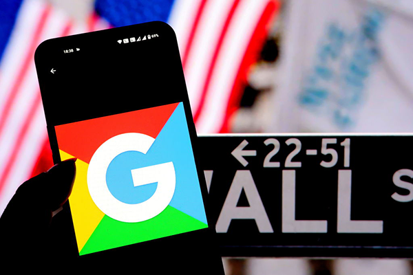Montage of Alphabet's Google logo on a smartphone against a Wall St sign and US flag Getty
