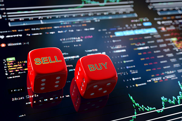 Dice saying 'buy' and 'sell' against a trading screen Getty image