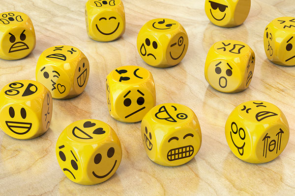 Dice with happy or sad expressions on them Getty