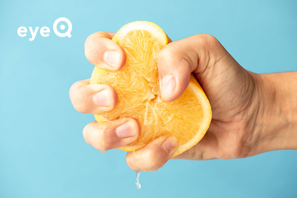 eyeQ hand squeezing an orange