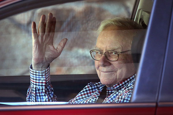 Warren Buffett waving through a car window Getty