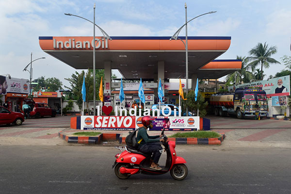 A rider on a scooter passes an Indian Oil petrol pump in Kolkata, India Getty