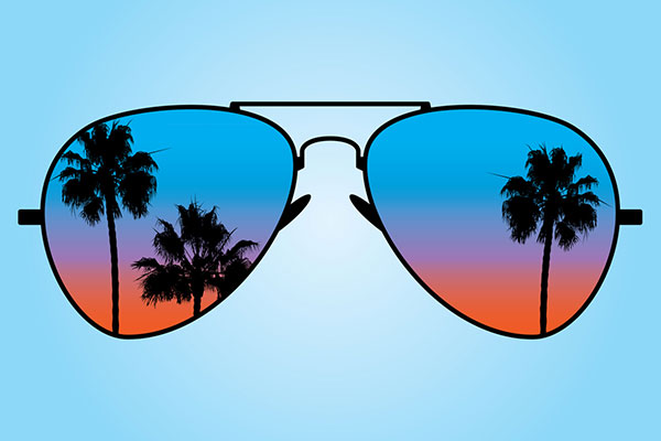 Sunglasses at sunset with palm trees reflected in them