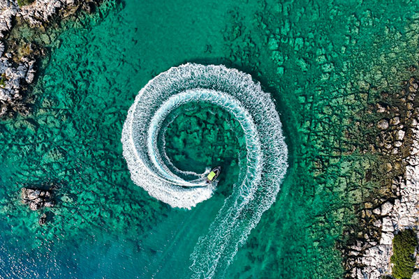 A boat turning around in a circle in turquoise water