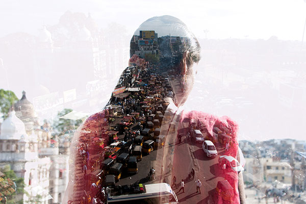 Double exposure of a woman and Indian cityscape Getty