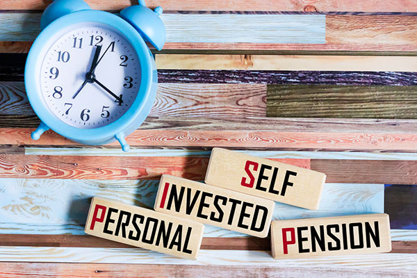 A clock with self-invested personal pension written on blocks