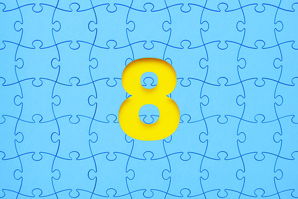 Blue jigsaw puzzle pieces forming a cut-out number eight on yellow background