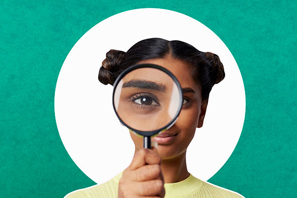 Woman taking a closer look with a magnifying glass Getty