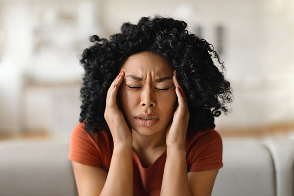 Close-up shot of stressed woman touching her head with her hands 