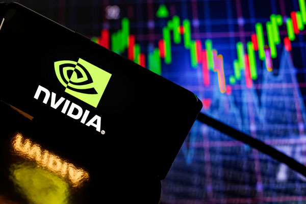 Nvidia logo on a smartphone against a screen displaying stock graphs Getty