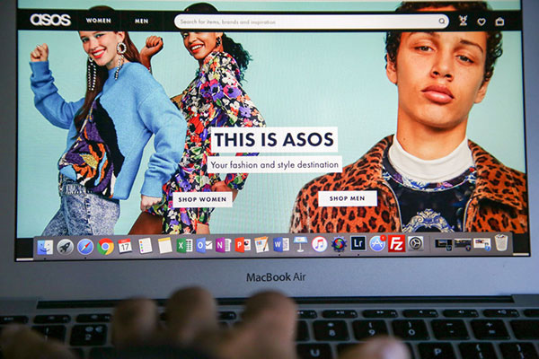 A person shopping on the ASOS the online fashion store on a laptop Getty