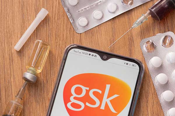 GSK logo amid vaccine, packets of tablets