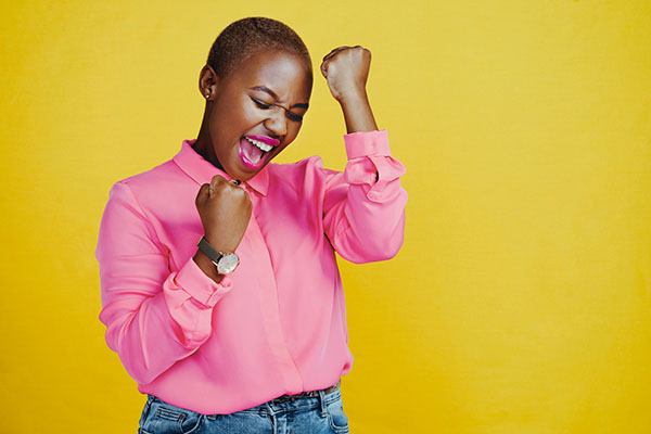 Young woman feeling cheerful against a yellow background