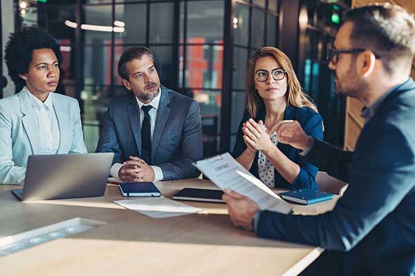 A group of colleagues listening to a manager in a meeting