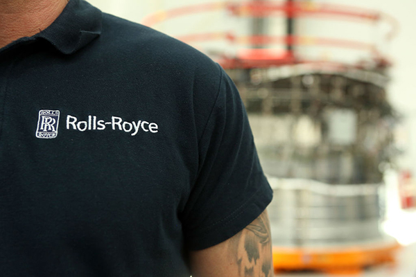 Man working in Rolls-Royce factory with logo on his uniform getty