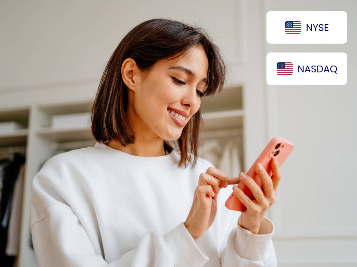 Woman smiling using smartphone to trade US stocks