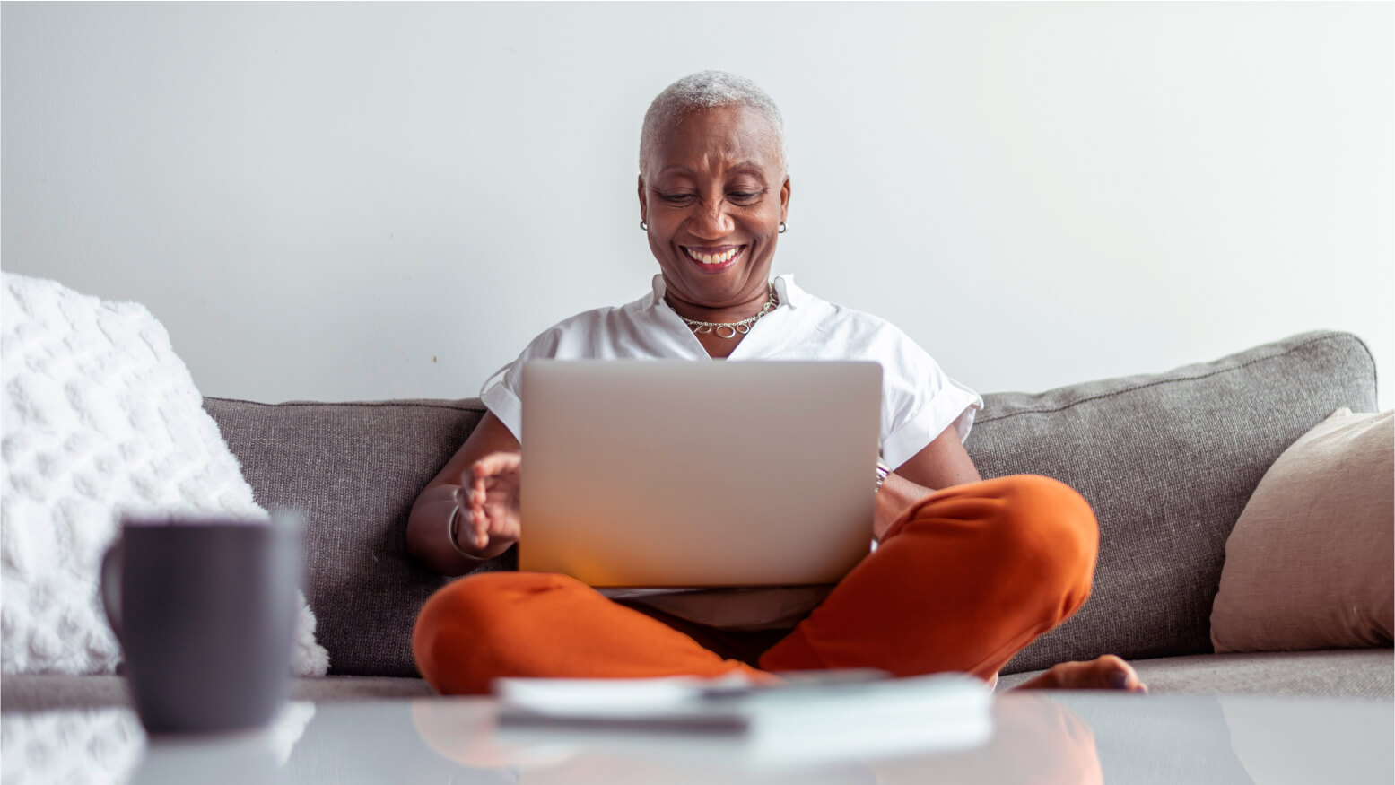 woman trading on laptop on sofa