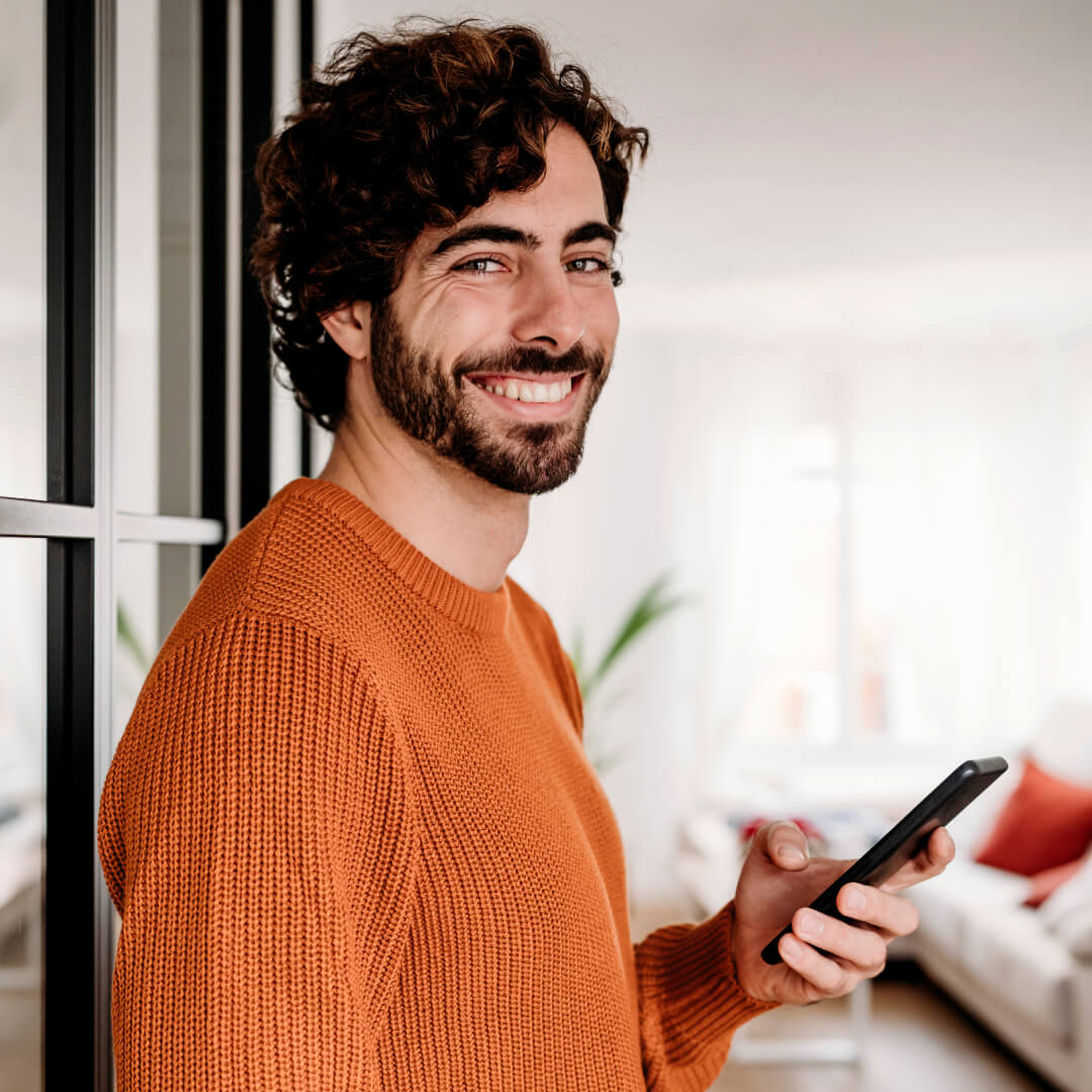 young male mobile phone user smiling