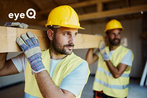 eyeQ Two builders carrying a plank of wood