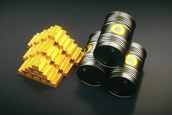 Gold bars alongside barrels of oil on a black background