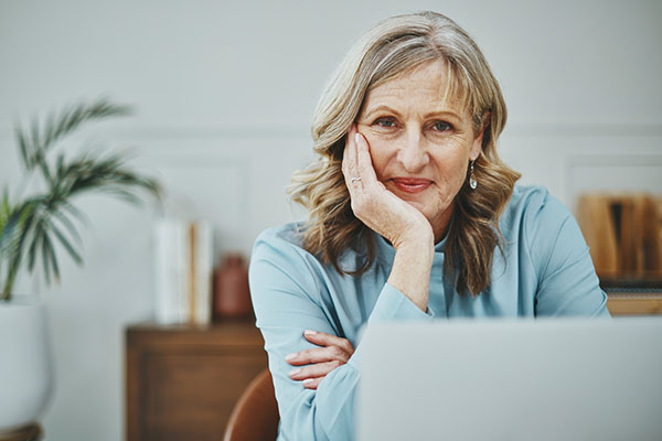 Happy older investor sitting at computer