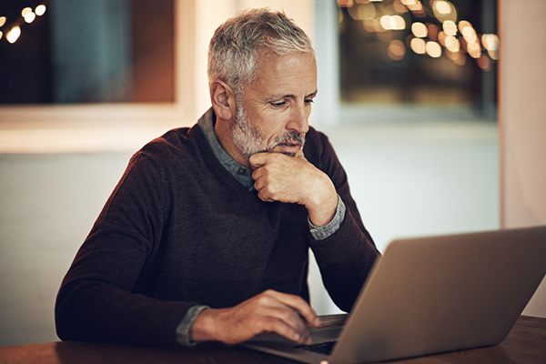 Man sitting at a laptop thinking about fixed income investing